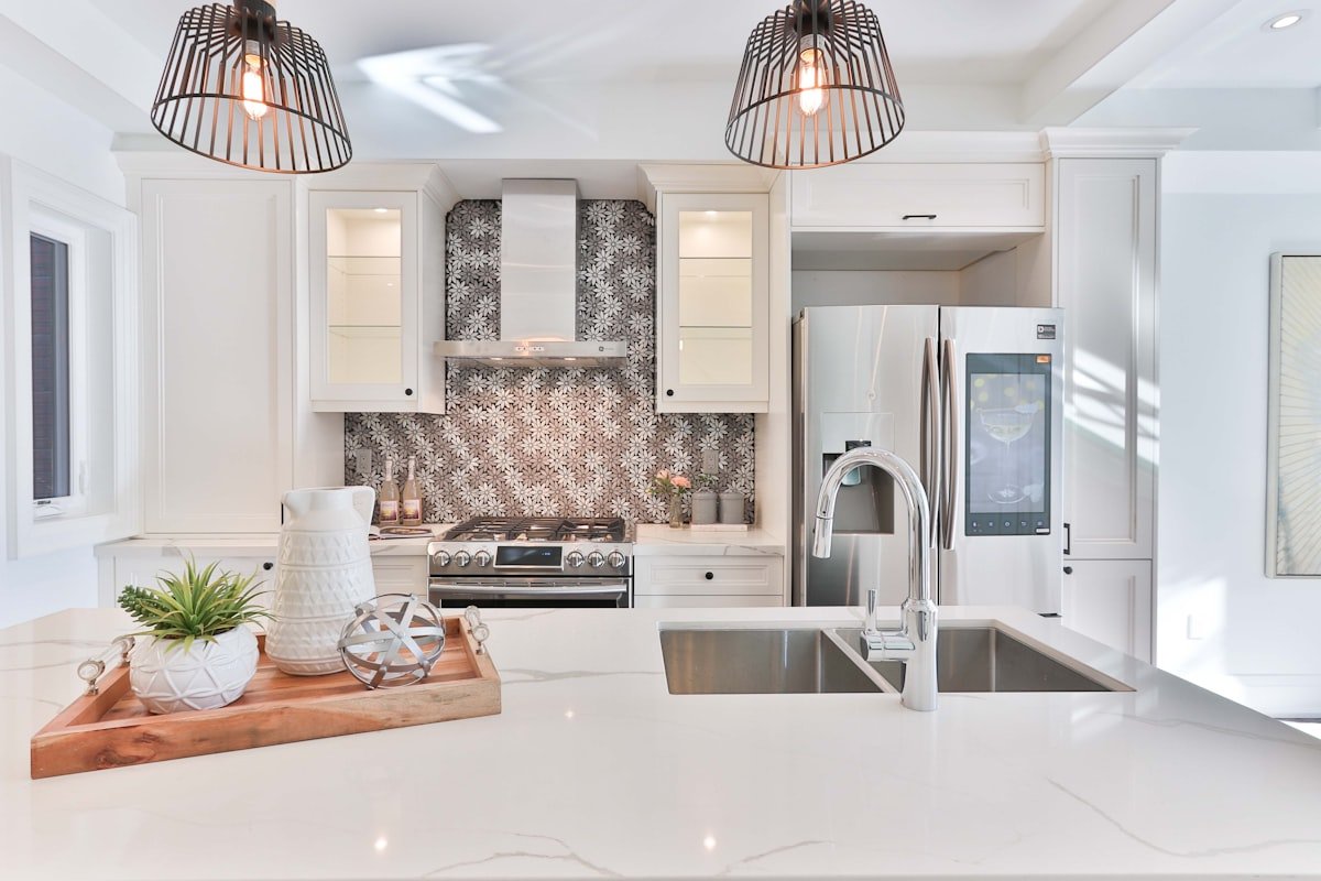 Built-in library wall with white cabinetry, open shelves, books, and brass picture lights