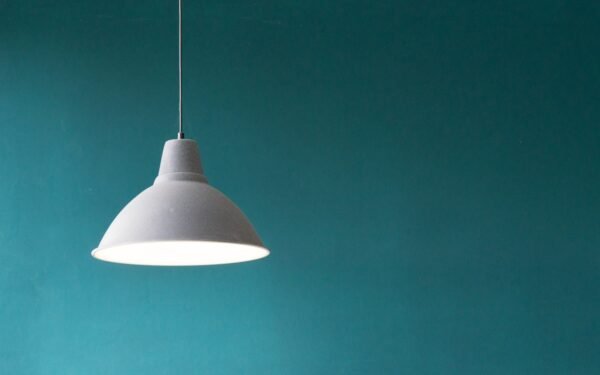 Warm ambient dining room lighting with sculptural pendant and low table lamps