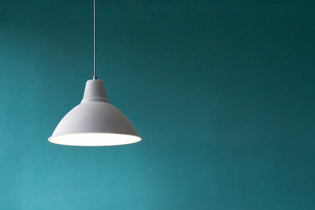 Warm ambient dining room lighting with sculptural pendant and low table lamps