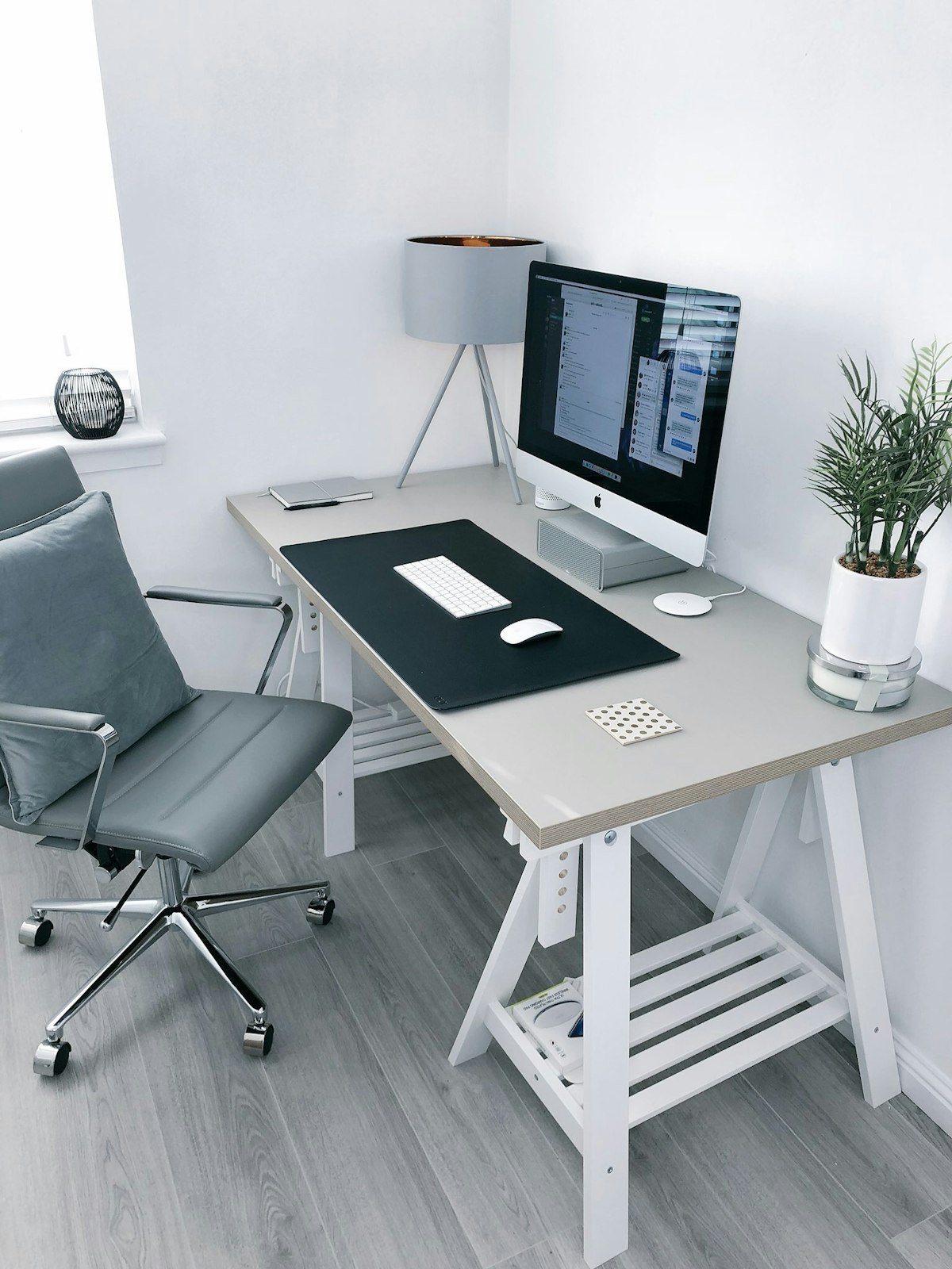 Minimalist Scandinavian home office desk with ergonomic chair, laptop, and plant