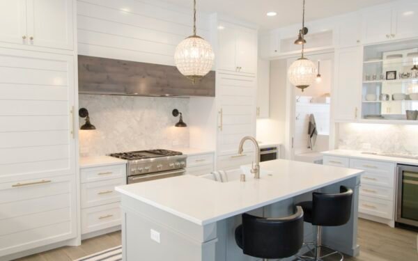 Spotless marble kitchen island with wood cutting board and clean pendant lights
