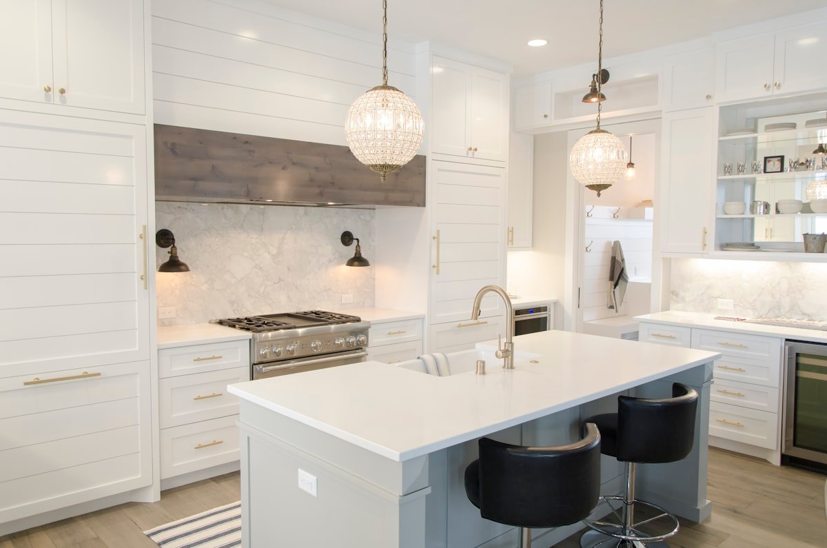 Spotless marble kitchen island with wood cutting board and clean pendant lights