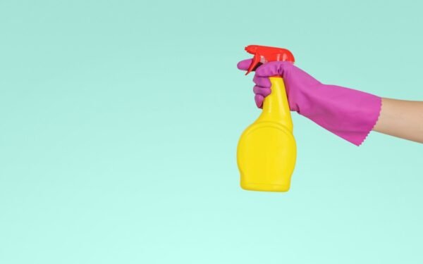 Organized cleaning supplies in portable wooden caddy with glass spray bottles
