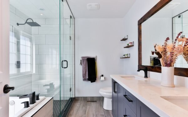Neatly organized bathroom vanity with glass jars, rolled towels, and plant