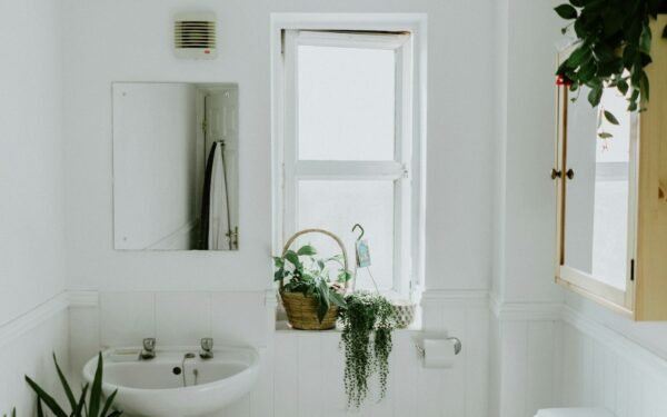 Compact spa-style bathroom with floating shelves, white subway tile, and rolled towels