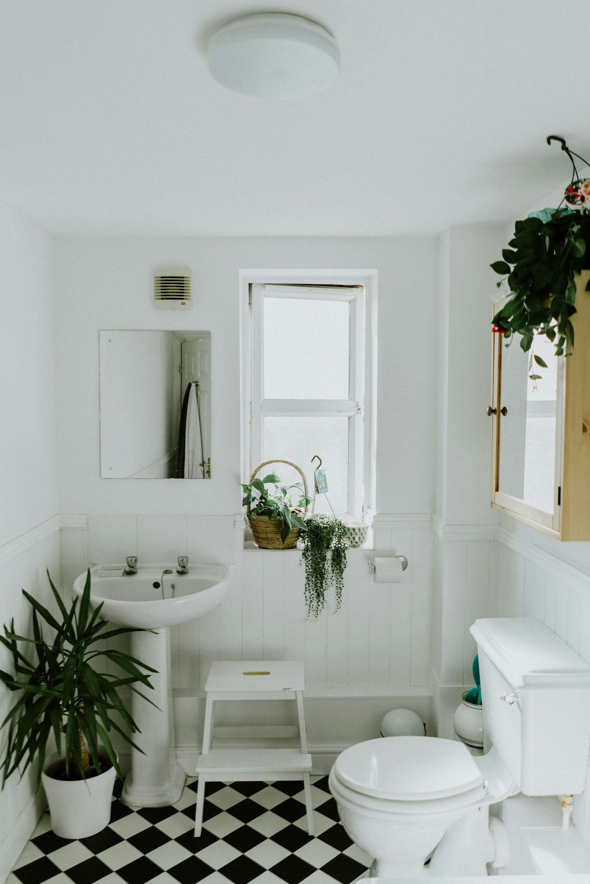 Compact spa-style bathroom with floating shelves, white subway tile, and rolled towels